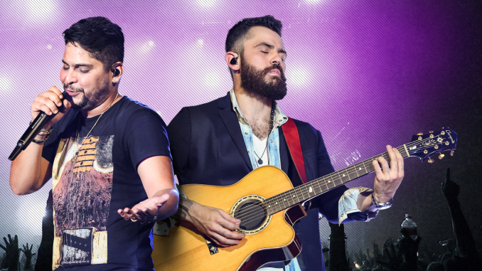 Jorge e Mateus cantando e tocando violão no palco