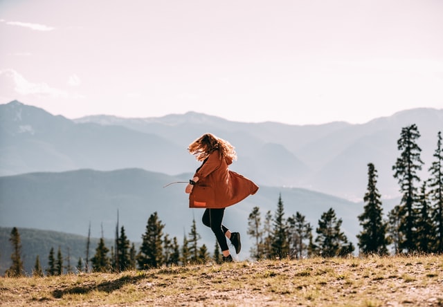 Mulher rodando no meio de um campo.
