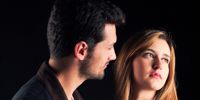 Homem e mulher lado a lado. Ela está com o rosto virado. 
