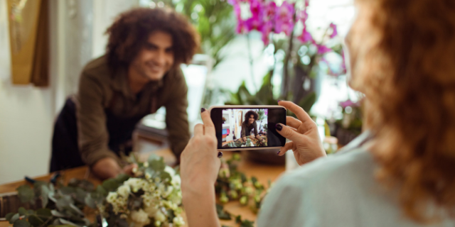 Geber86 / Canva Mulher, com um celular, fotografa homem.