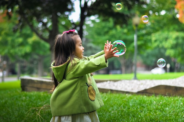Menina brincando com bolhas de sabão