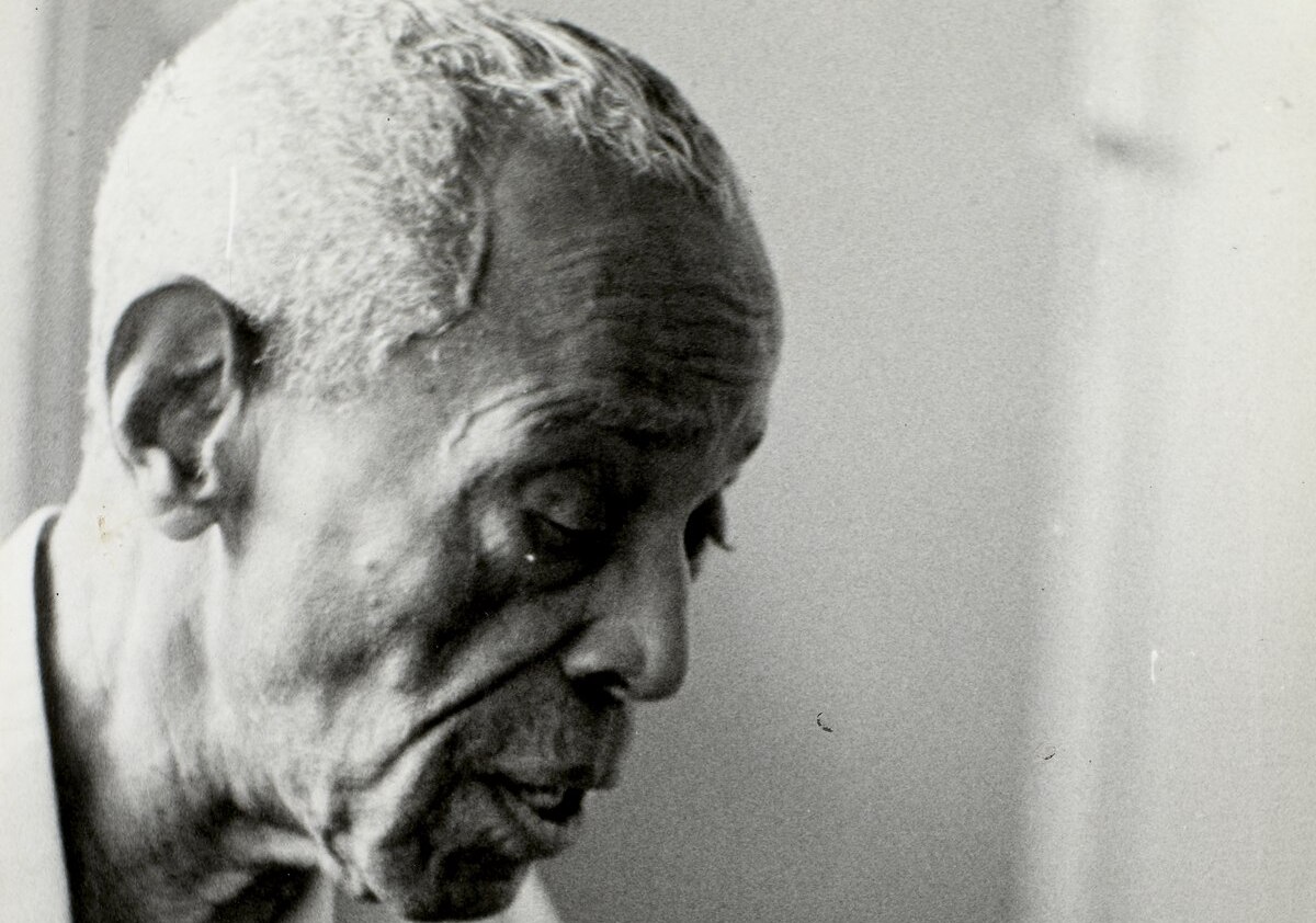 Homem negro olhando para baixo.