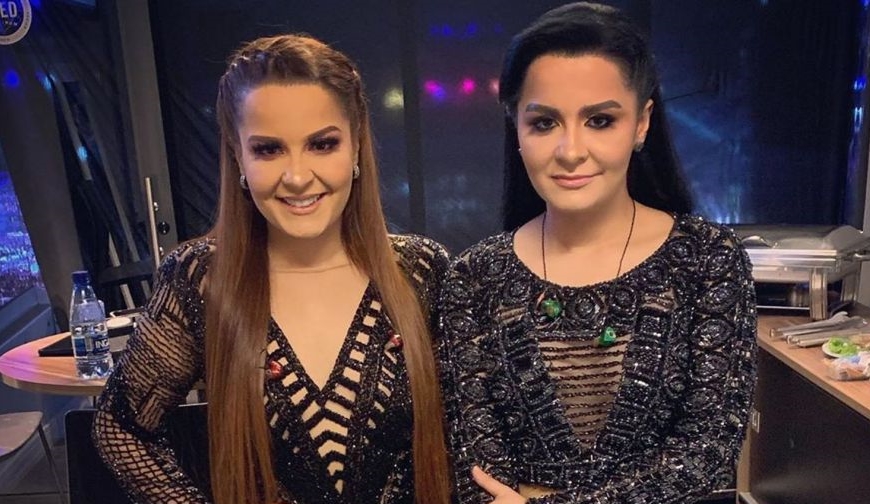 Maiara e Maraisa olhando para frente em um estúdio de televisão