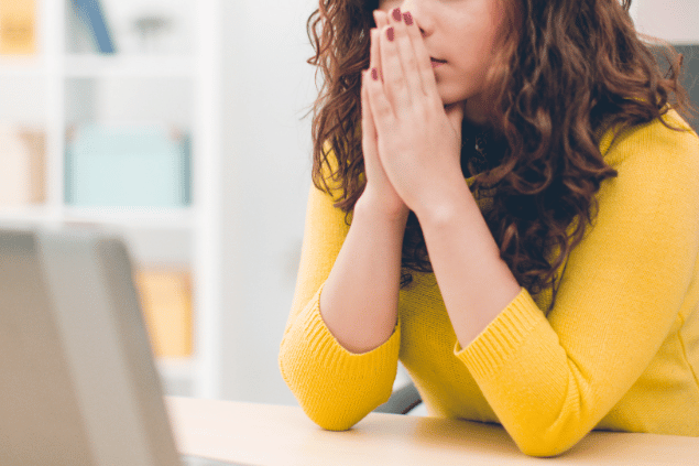 mulher com um semblante de preocupação diante um computador