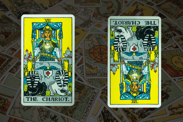 Montagem com a carta O Carro do Tarot na posição normal e outra carta O Carro na posição invertida. Ao fundo, há várias cartas de Tarot.