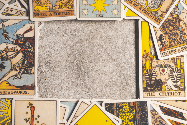 Há várias cartas de Tarot espalhadas sobre uma mesa.