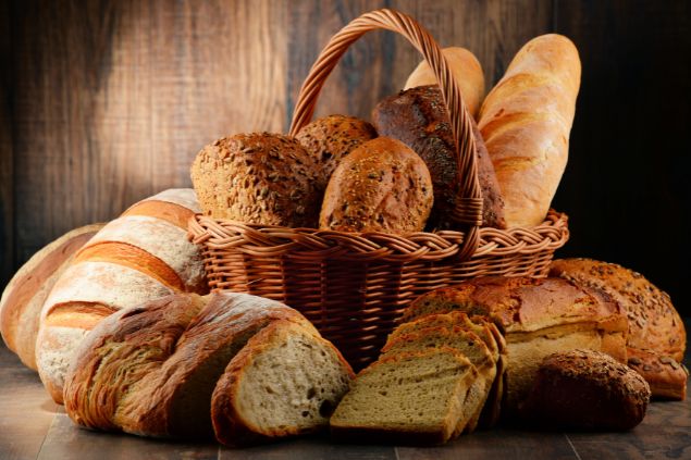 Vários pães grandes dentro e fora de um cesto.