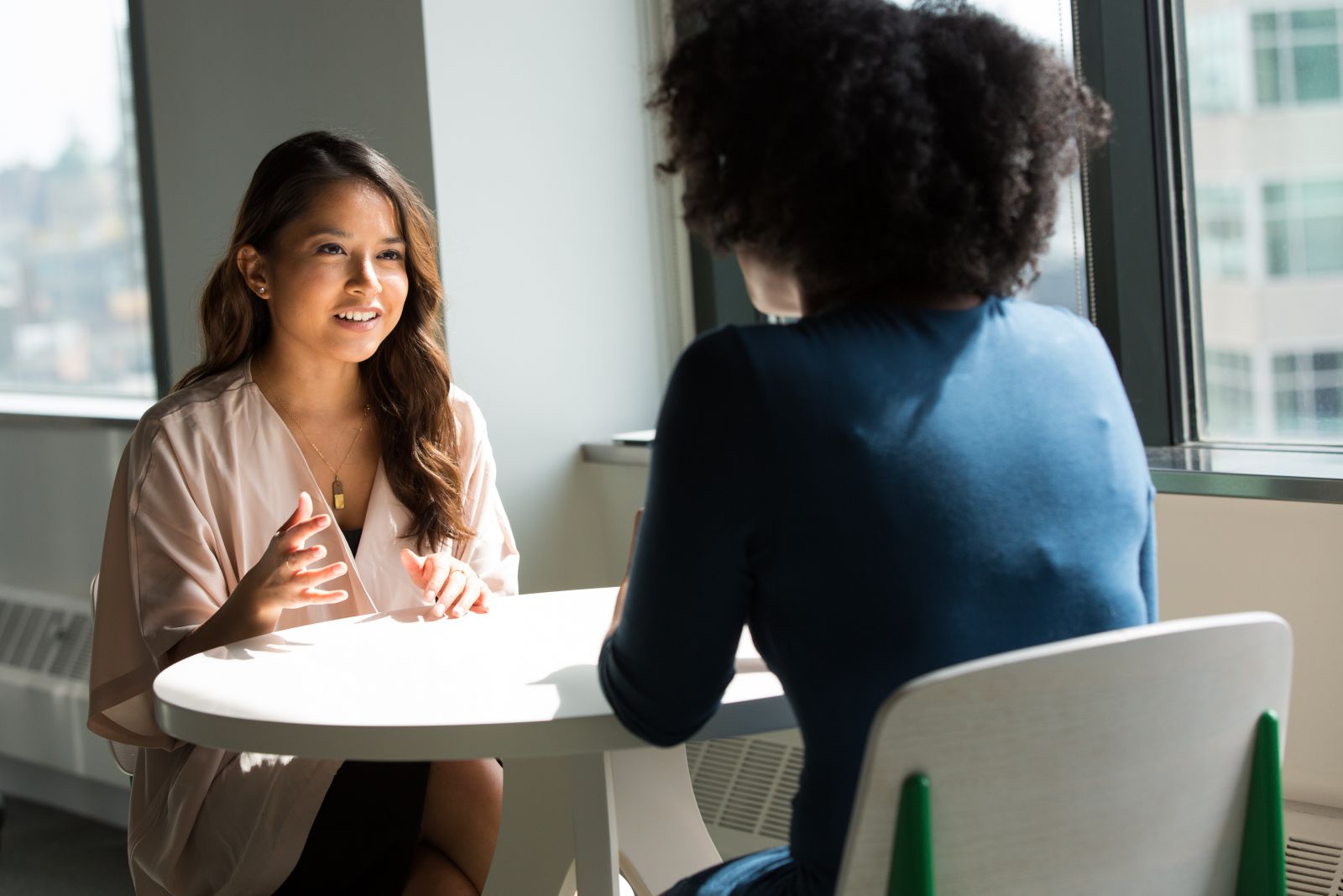 Duas mulheres em uma mesa conversando e sorrindo