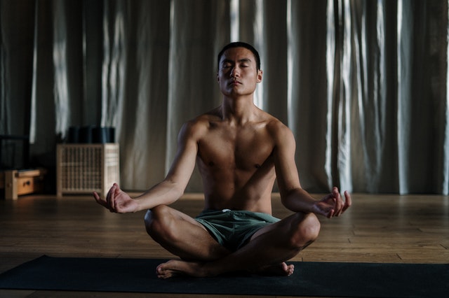 Homem sentado em posição de lótus meditando