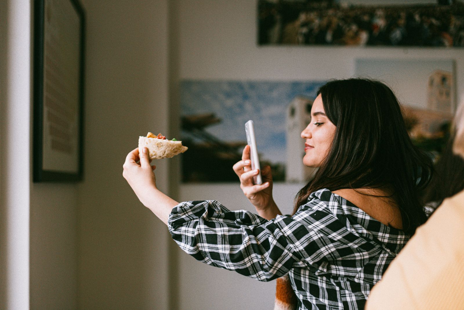 Mulher fotografando um alimento que está segurando