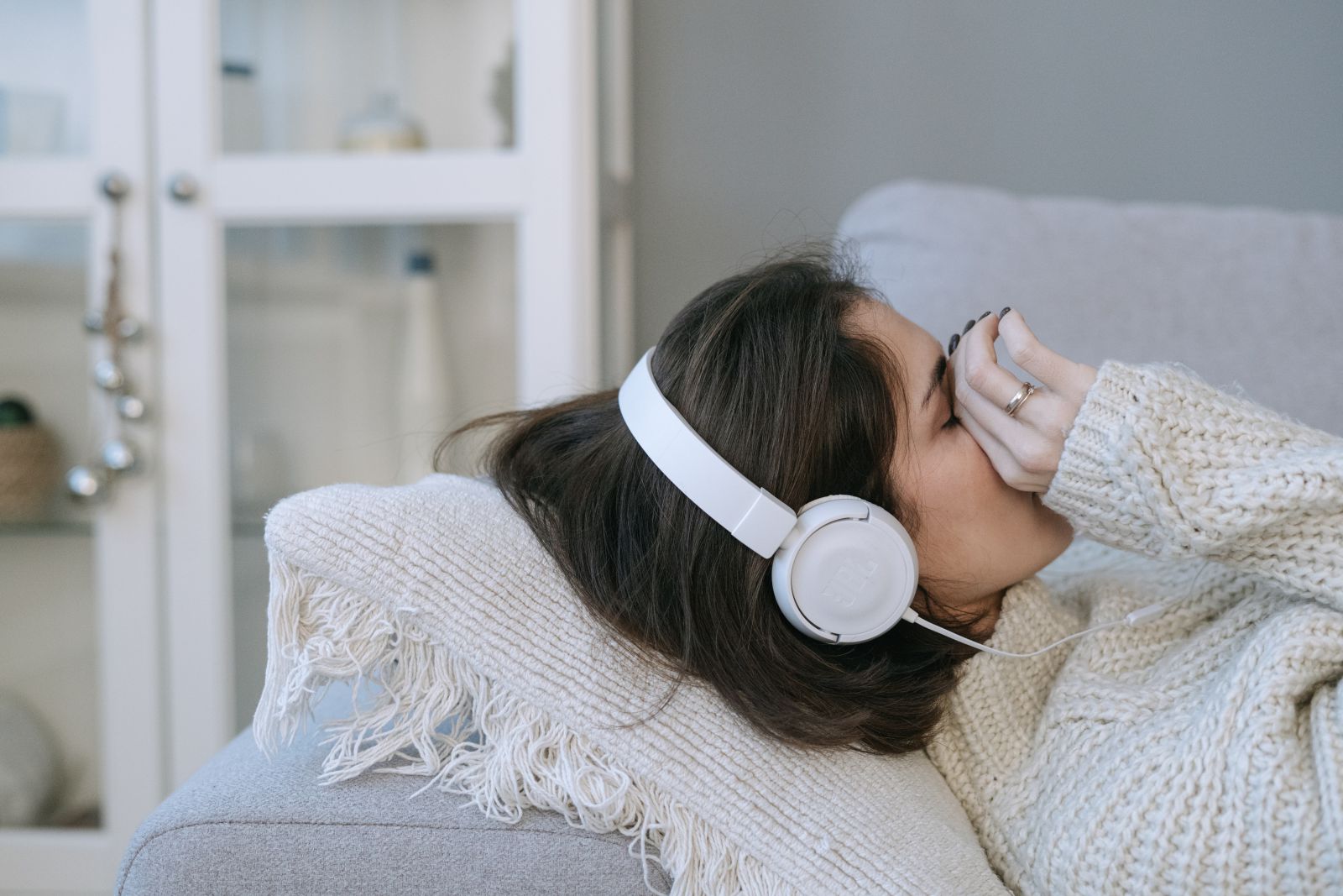 Mulher deitada no sofá chorando