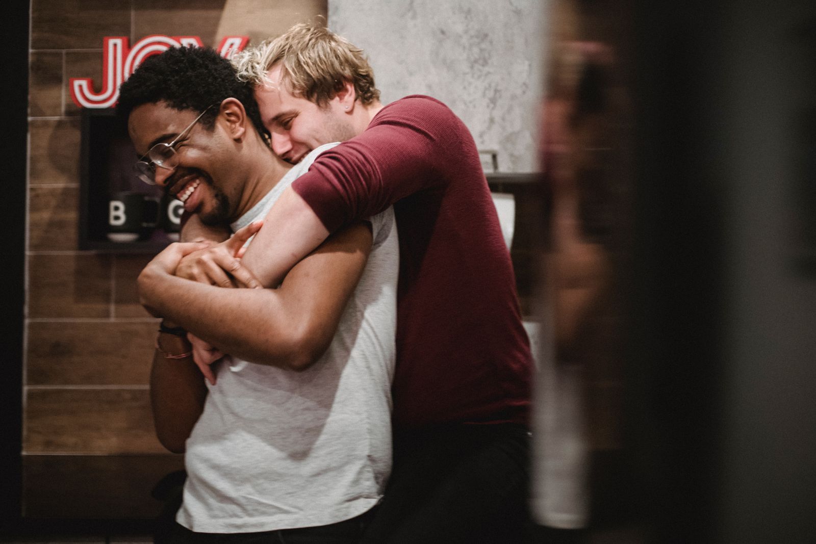 Dois homens se abraçando e sorrindo