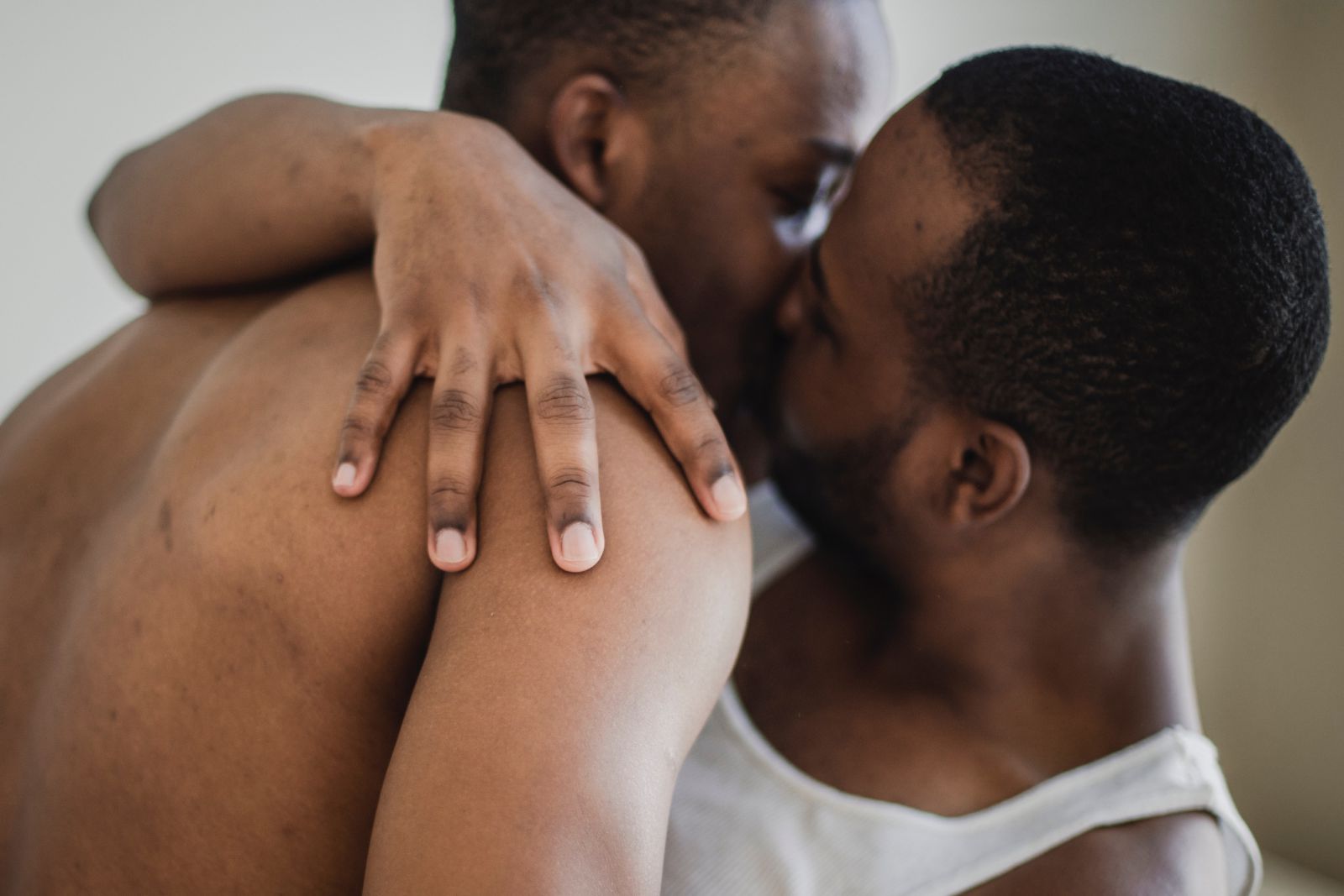 Casal de homens abraçados se beijando