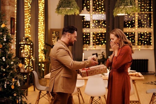 Homem entrando dois presentes de Natal para mulher 