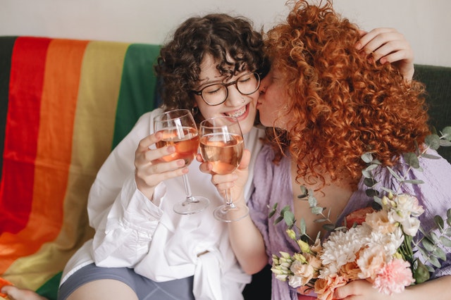 Mulheres brancas sorrindo e segurando taças.