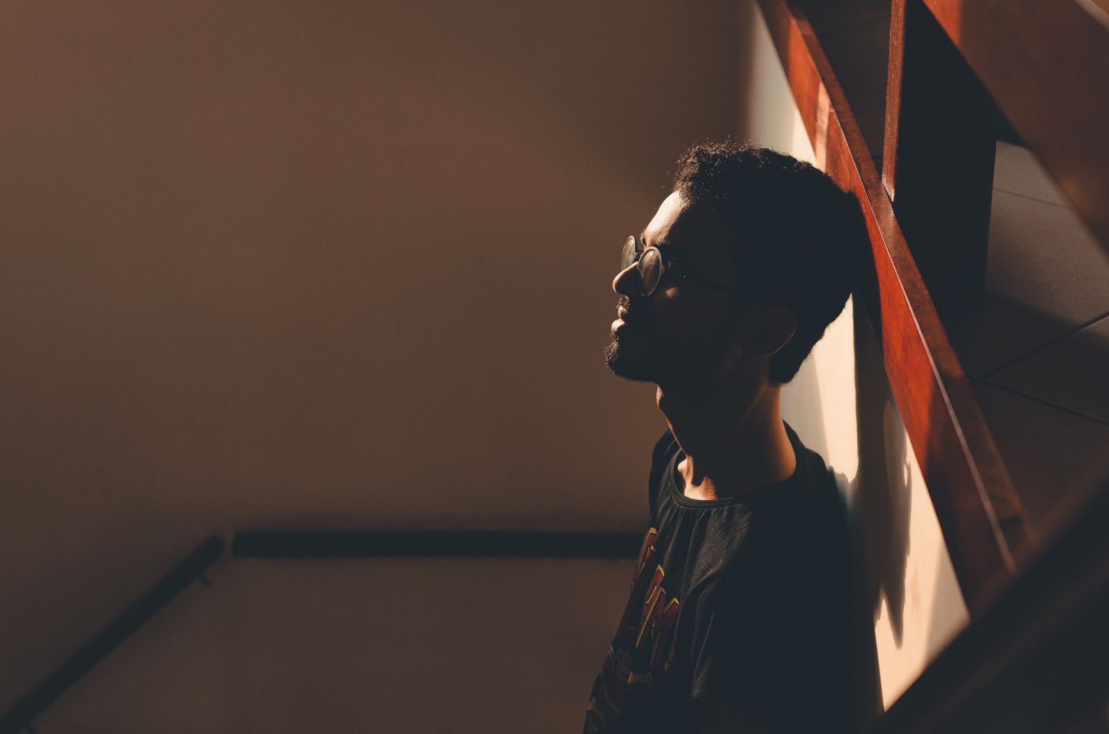 Homem apoiando sua cabeça na parede