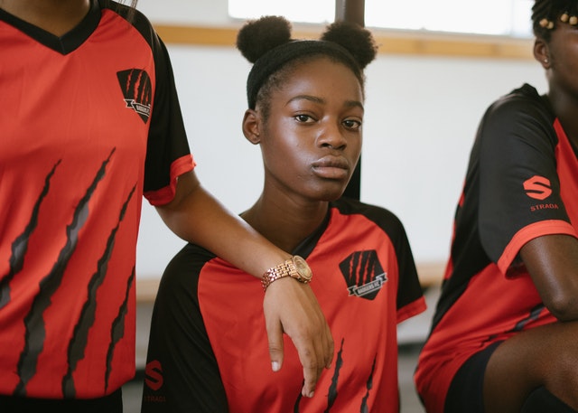 Jogadora negra usando uniforme vermelho e preto