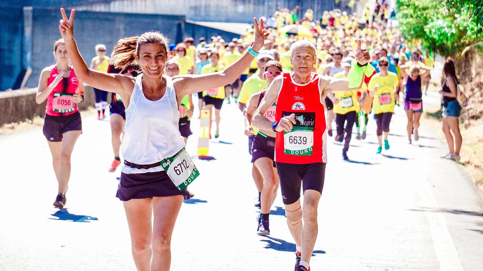 Mulher sorrindo em uma corrida ao lado de um senhor 