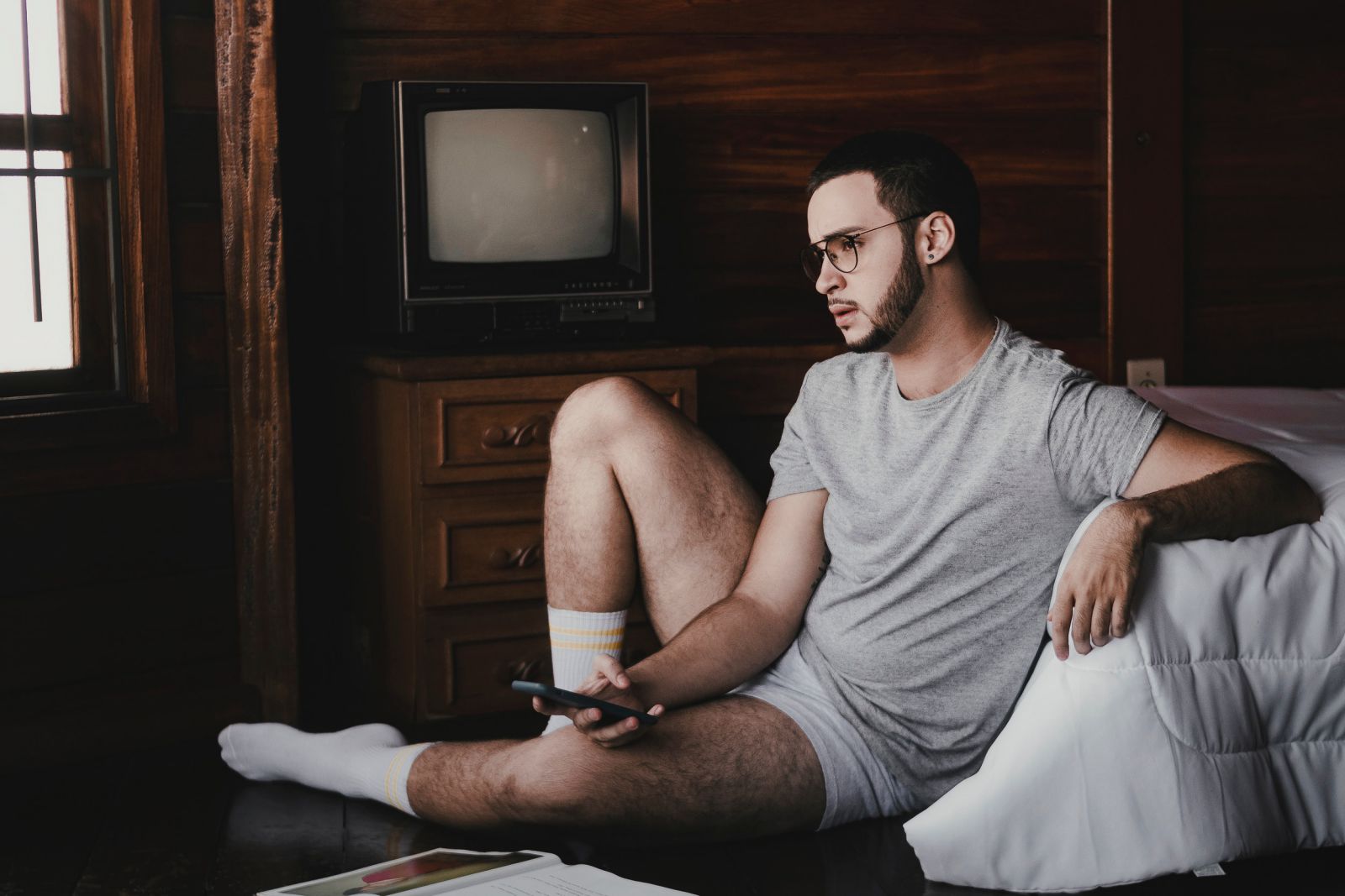 Homem sentado no chão segurando controle da TV