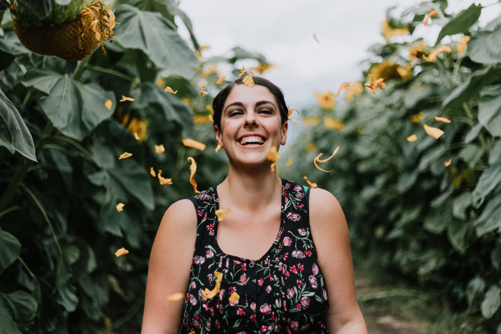 Mulher sorrindo em um jardim com flores voando