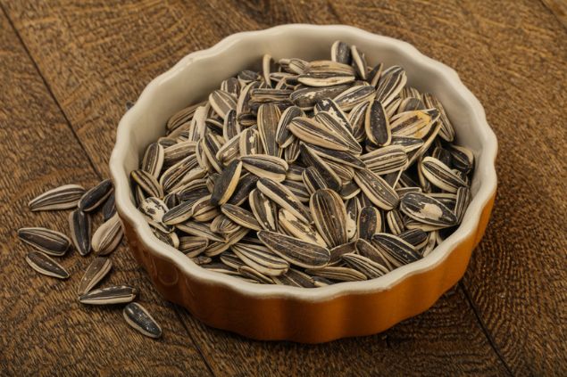 Um punhado de sementes de girassol dentro de um pote.