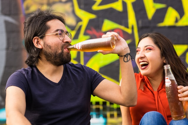 Homem e mulher brancos bebendo.