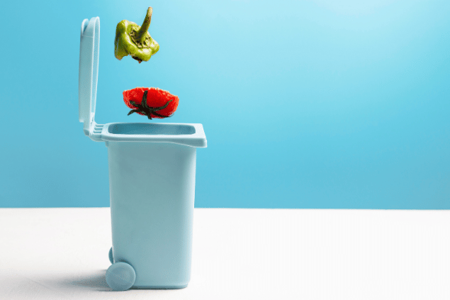 Comida desperdiçada caindo no lixo.