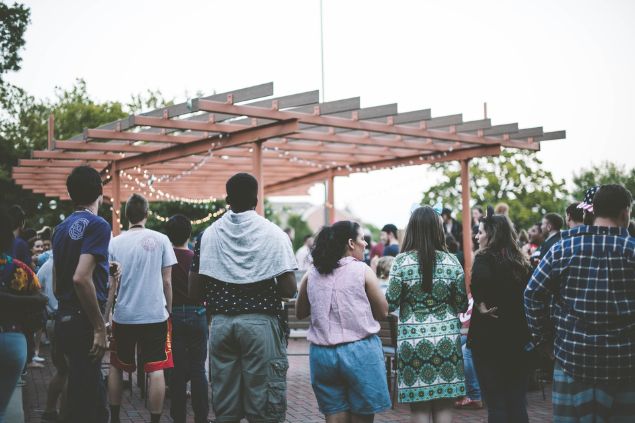 Muitas pessoas reunidas ao ar livre, em uma espécie de festividade.