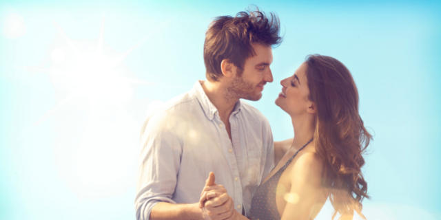 Casal dança em cenário azulado.