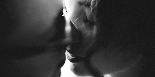 Homem e mulher se beijam. 