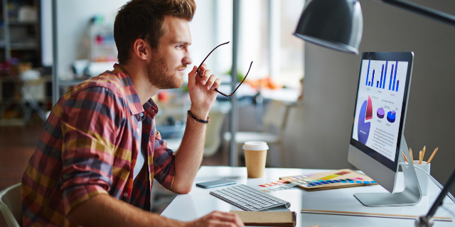 Homem trabalha em frente ao computador. 
