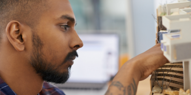Homem organiza coisas em prateleira.