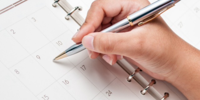 Mulher escreve em calendário.