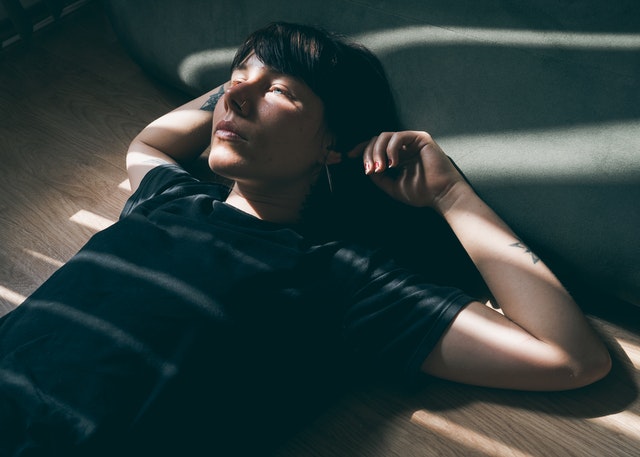 Mulher deitada com os braços atrás da cabeça.