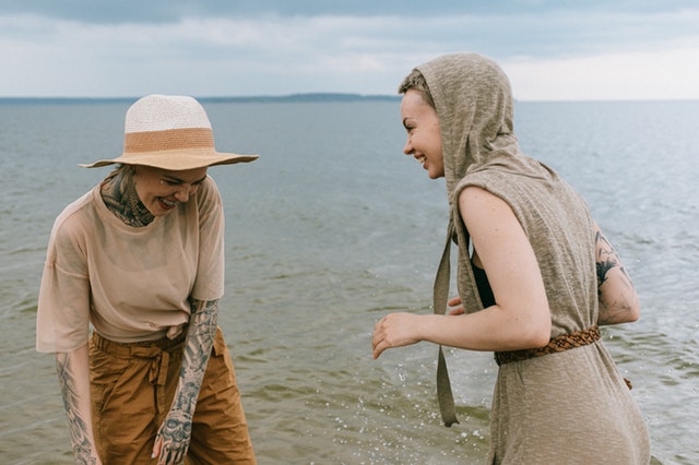 Mulheres sorrindo em beira de lago