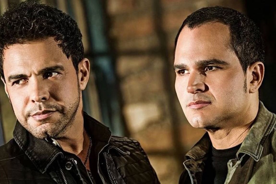 Zezé di Camargo e Luciano usando jaqueta e olhando para o lado